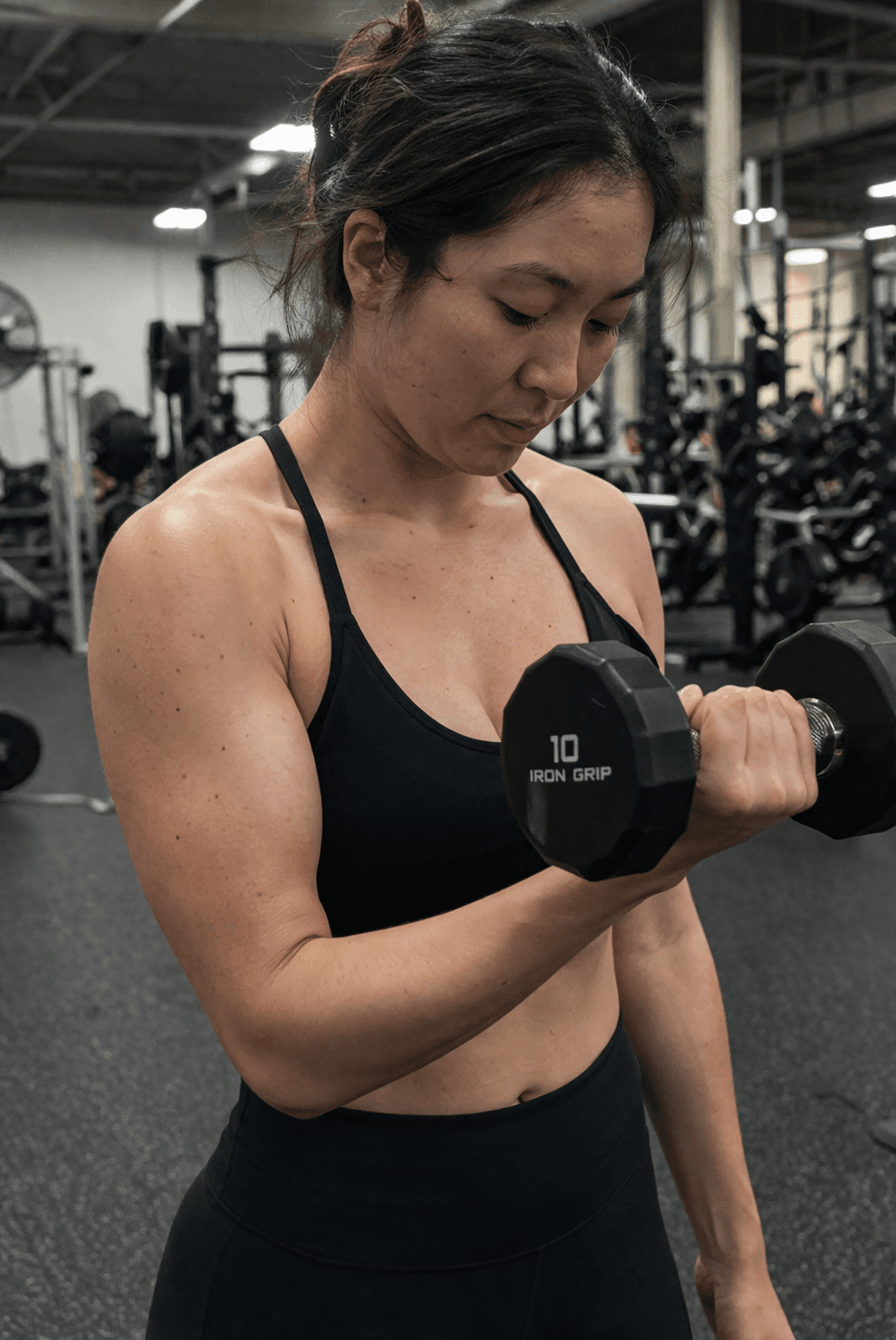 Woman lifting a dumbbell in a gym.